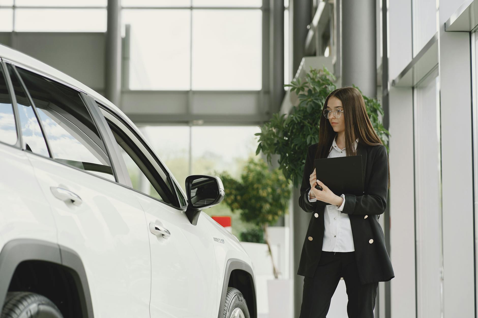 employee of luxurious dealership standing in front of car