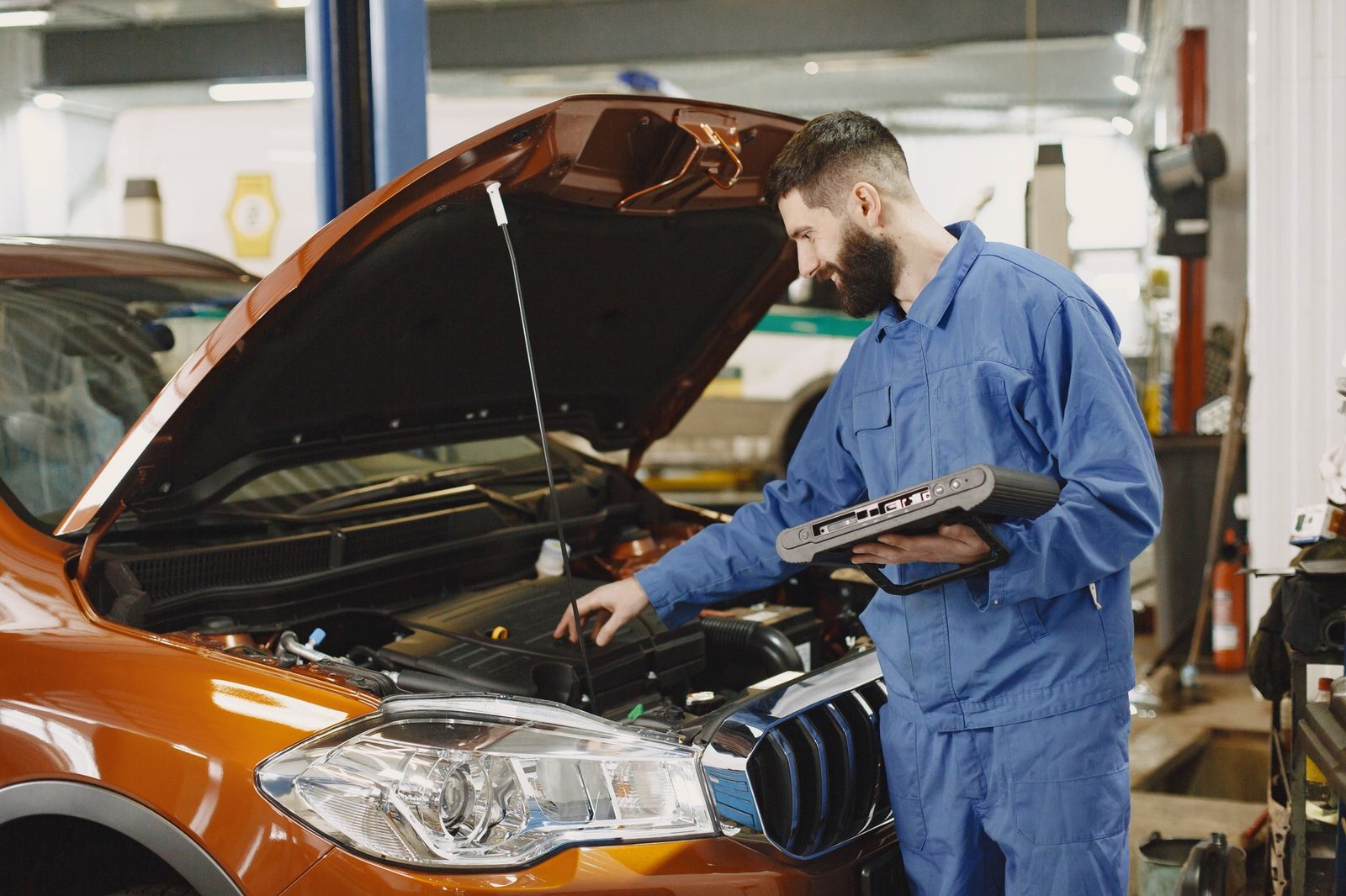 mechanic checking the engine of a car